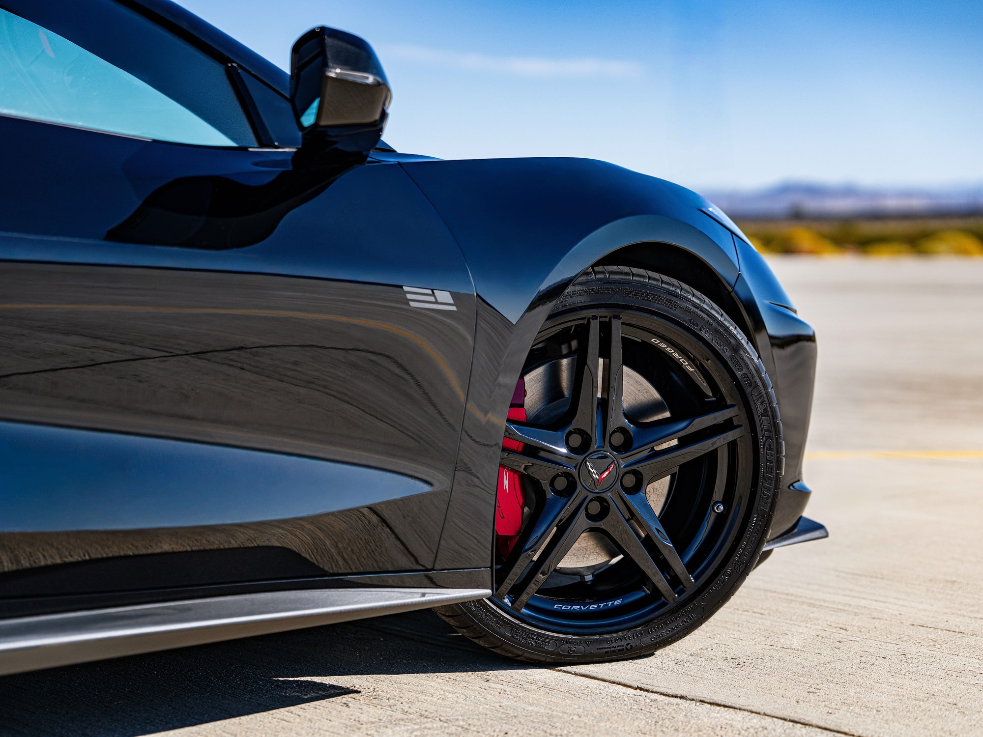 A Side View Close-Up of the Front Wheel on a Chevrolet Corvette Stingray with Red Brake Calipers.