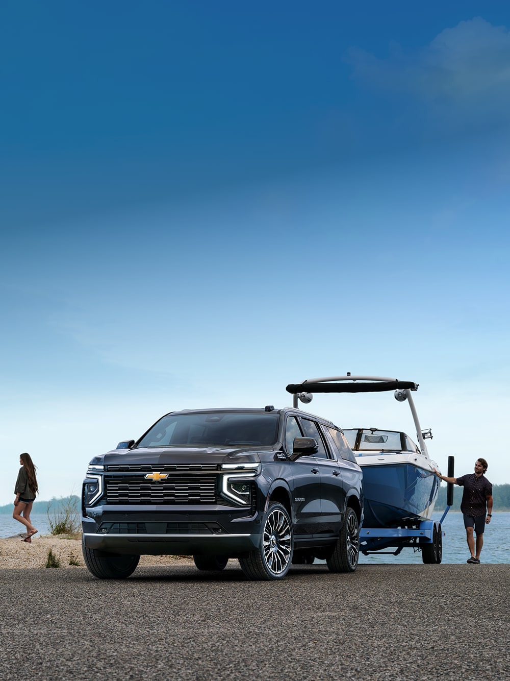 A Family at the Lake Next to Their 2026 Chevrolet Suburban Towing a Speed Boat