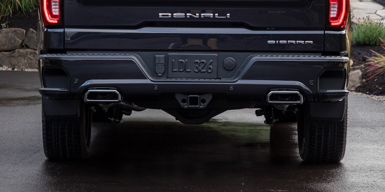 Rear View of a Blue Sierra 1500 Denali Luxury Pickup Truck Driving up a Winding Road