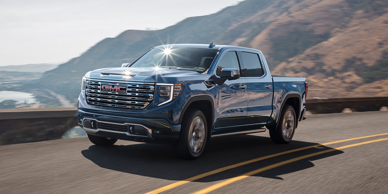 The 2026 GMC Sierra Denali Luxury Pickup Truck Driving Along the Coast as the Sun Shines off the Windshield